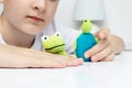 A caucasian boy playing different roles by using finger puppets, toys for expressing his emotions, agression, fear and freandship Royalty Free Stock Photo