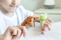 A caucasian boy playing finger puppets, toys, dolls - figures of animals, heroes of the puppet theatre put on fingers of human