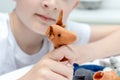 A caucasian boy playing finger puppets, toys, dolls - figures of animals, heroes of the puppet theatre put on fingers of human