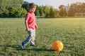 Caucasian boy playing soccer football on playground outside. Preschool kid kicking hitting ball. Happy authentic candid childhood Royalty Free Stock Photo