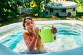 Caucasian child playing with water in an inflatable pool in the home garden at summer evening Royalty Free Stock Photo