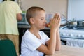 Caucasian boy prays at home at table before eating. Stay home and pray to god. Royalty Free Stock Photo