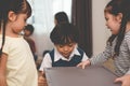 Caucasian boy scrambling for toys in plastic cupboard with her sisters. Family and children concept. Conflict and quarrel theme.