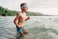 Caucasian boy swimming in lake river with underwater goggles. Child diving in water on a beach. Authentic real lifestyle happy Royalty Free Stock Photo