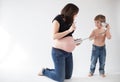 Funny boy trying to listen inside the belly of a pregnant woman with a tin can phone Royalty Free Stock Photo