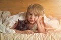 Caucasian boy  wakes up in the morning in bed hugging his beloved pet black cat. Friends covered with a blanket with Royalty Free Stock Photo