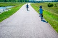 Caucasian boy wearing a helmet while riding a bike down a paved park path Royalty Free Stock Photo