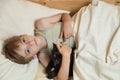 Caucasian boy goes to sleep in bed hugging his beloved pet black cat Royalty Free Stock Photo