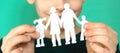 caucasian boy 7 years old holds a family cut out of paper in his hands. , shallow depth of field. the child dreams Royalty Free Stock Photo