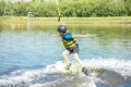 Caucasian boy of 10 years old in a protective suit, active wakeboard training with fun activities in water sports adventure, Royalty Free Stock Photo