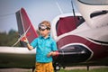 Caucasian boy in yellow shorts, a blue shirt and in aviation points holds the toy plane in hand and h