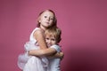 Caucasian brother and sister ,hugging on camera on pink background studio shot.