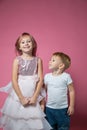 Caucasian brother and sister ,hugging on camera on pink background studio shot.