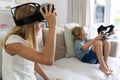 Caucasian brother and sister sitting on couch removing vr headsets