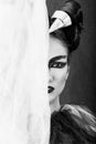 Caucasian Brunette with Half Face Covered with White Cloth and Half Face Painted with Graphic Black Make-up, in Black and White Royalty Free Stock Photo