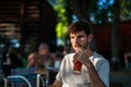 Caucasian brunette young man drinking a smoothie with a straw in a terrace Royalty Free Stock Photo