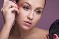 Caucasian brunette woman tweeze her eyebrowns. Close up portarait. Skin care concept