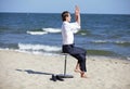 Caucasian business man exercising on pneumatic stool on the beach