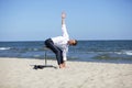 Caucasian business man stretching body on pneumatic stool on the beach