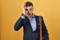 Caucasian business man over yellow background doing ok gesture shocked with surprised face, eye looking through fingers Royalty Free Stock Photo