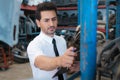 Caucasian business manager stand, checking auto part in factory-warehouse