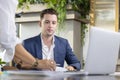 Caucasian business manager is working in eco friendly office surrounding by green plant while his secretary give him approval Royalty Free Stock Photo