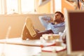 Caucasian business person sitting in office thinking daydreaming hands behind head. Royalty Free Stock Photo