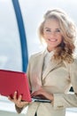 Caucasian business woman holding laptop and smiling looking at camera Royalty Free Stock Photo