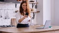 Caucasian business woman holding phone in a kitchen Royalty Free Stock Photo