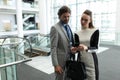 Caucasian businessman and Caucasian businesswoman discussing over mobile phone near escalator Royalty Free Stock Photo