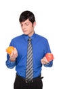 Caucasian businessman comparing apple to orange