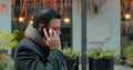 Caucasian businessman in glasses walking the street and talking on the phone. Handsome male speaking on mobile phone and Royalty Free Stock Photo