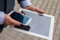 Caucasian businessman outside office using white tablet pc on a