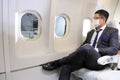 Caucasian businessman travels in formal wear with facial mask sitting comfortably in the aircraft with business class seat Royalty Free Stock Photo