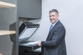 Caucasian businessman using photocopy machine Royalty Free Stock Photo