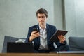 caucasian businessman working with tablet and mobile phone, wear suit, sitting, looking at mobile phone, computer or laptop on Royalty Free Stock Photo