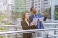 caucasian businesswoman in black suit and businessman in blue suit working together and looking at copy space outside building in