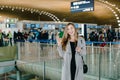 Caucasian businesswoman speaking by smartphone at airport hall, Royalty Free Stock Photo