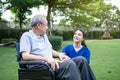 Caucasian Caregiver doctor talk with older disabled man on wheelchair. Attractive nurse taking care of senior elderly mature male Royalty Free Stock Photo