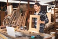 Caucasian carpenter is describing his wooden frame product to the online bidding customer in live streaming via internet for his
