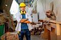 Caucasian carpenter man stand with arm-crossed or confidence action and look at camera in front of stack of timber and carpenter Royalty Free Stock Photo