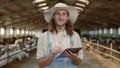 Caucasian cattleman using digital tablet on goat farm