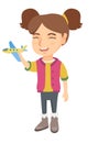 Caucasian cheerful girl playing with toy airplane.