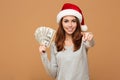 Caucasian cheerful lady wearing christmas hat pointing to you.