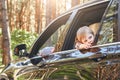 Cute little caucasian boy sitting inside the car and looking out the window. Family road trip Royalty Free Stock Photo