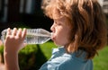 Caucasian child drinking water outdoor in park portrait close up. Kids face. Royalty Free Stock Photo