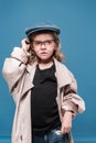 Caucasian child girl in glasses and oversized coat looking away