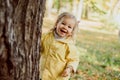 Caucasian child girl playing hide and seek in the park in autumn Royalty Free Stock Photo