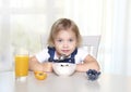 Caucasian child girl sitting at table and have a meal.Kid eating oatmeal with fruits,healthy nutrition Royalty Free Stock Photo