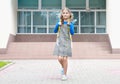 Caucasian child girl with yellow backpack at school yard outdoors.Back to school.Pupil portrait